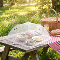 Folding Mesh Food Cover over a plate of food outdoors