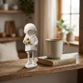 Banksy Deepsea Girl Figurine shown at true tabletop scale next to a coffee mug